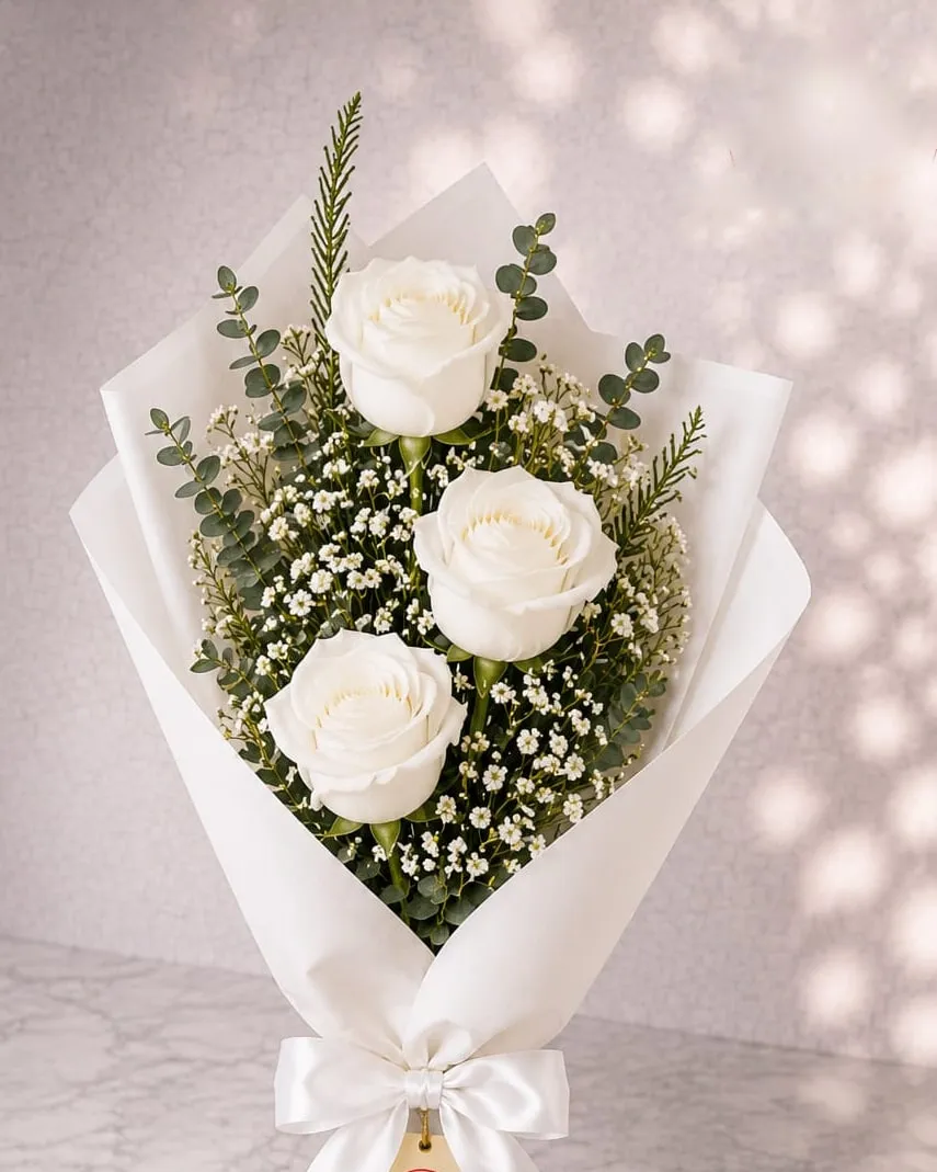 Ramo de tres rosas blancas con paniculata y eucalipto en papel blanco con cinta blanca