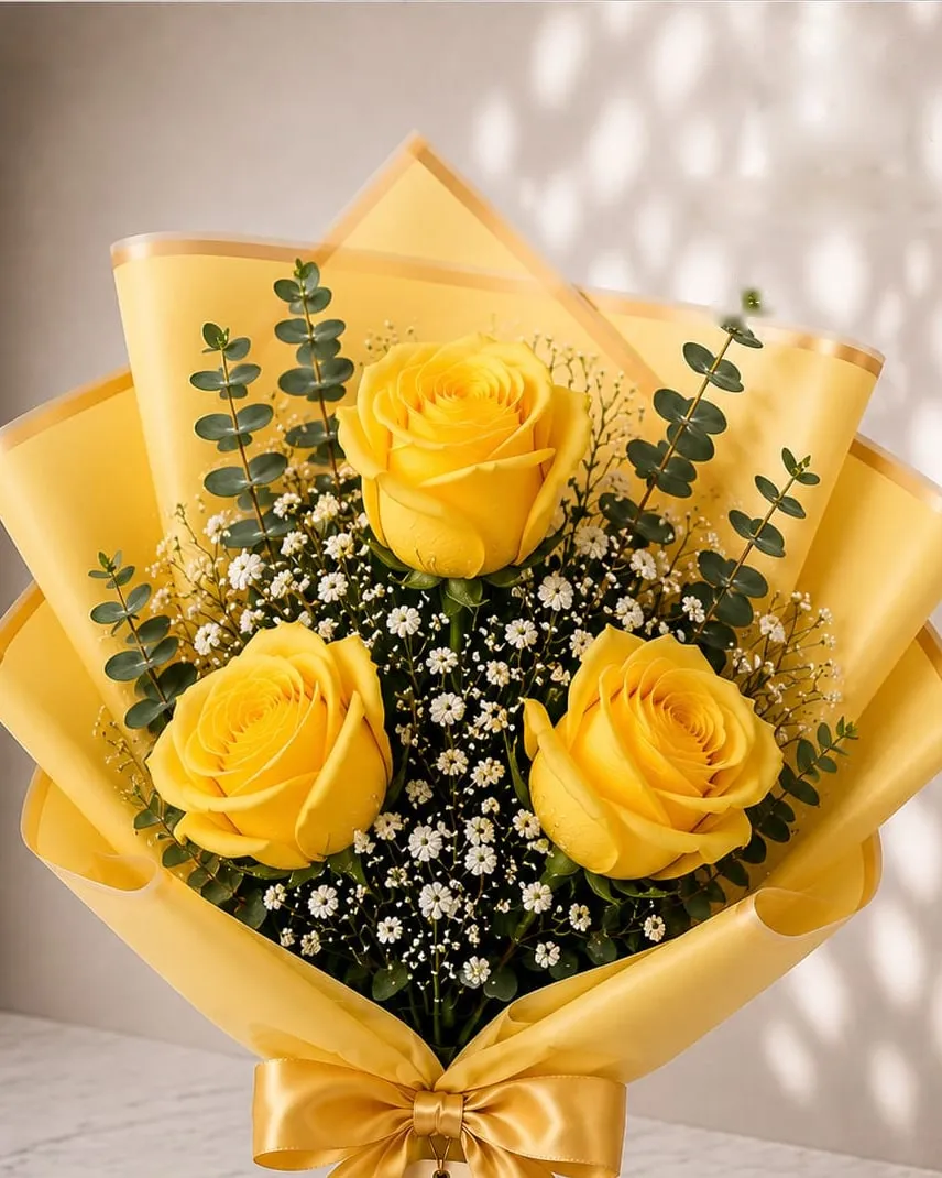 Ramo de tres rosas amarillas con paniculata y eucalipto en papel amarillo con cinta dorada