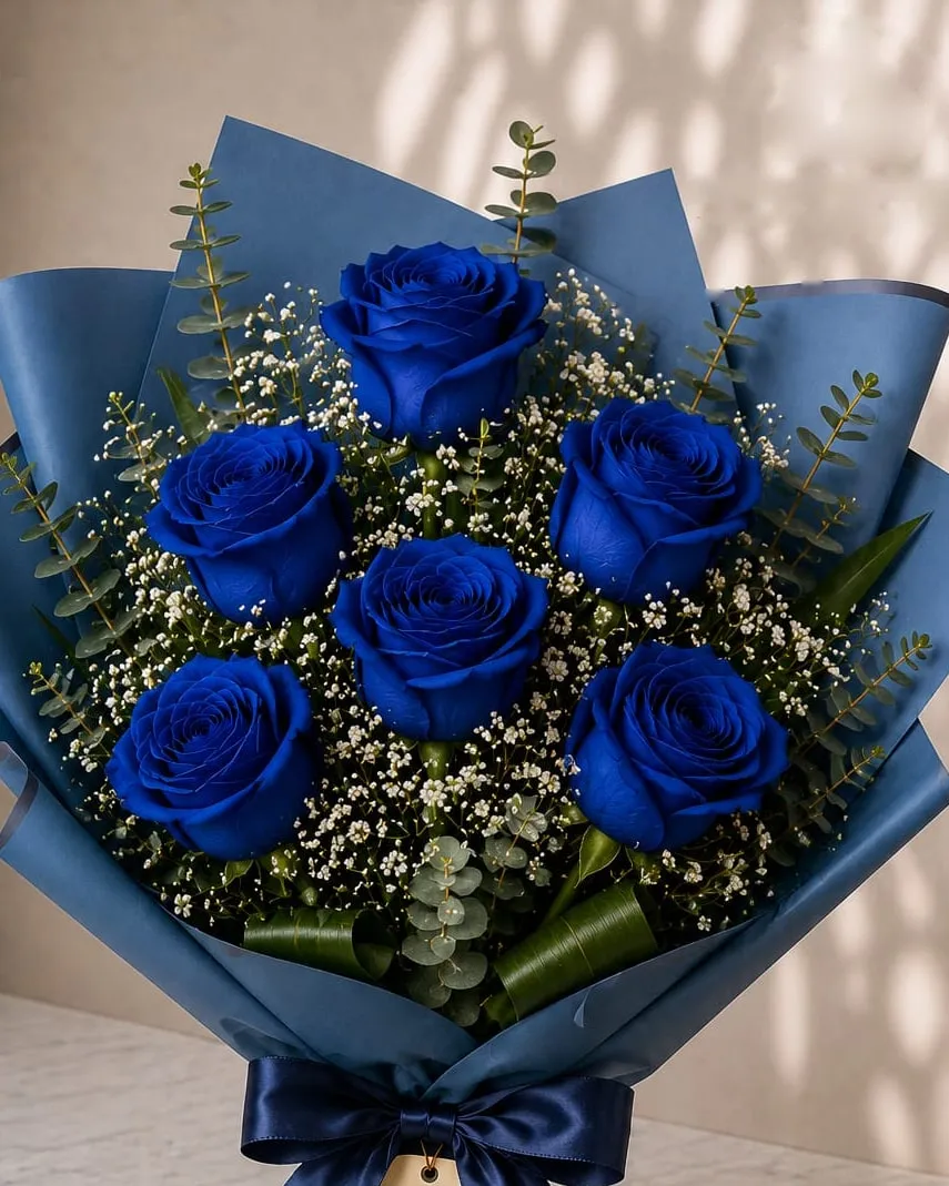 Ramo de seis rosas azules con paniculata y eucalipto en papel azul con cinta azul marino