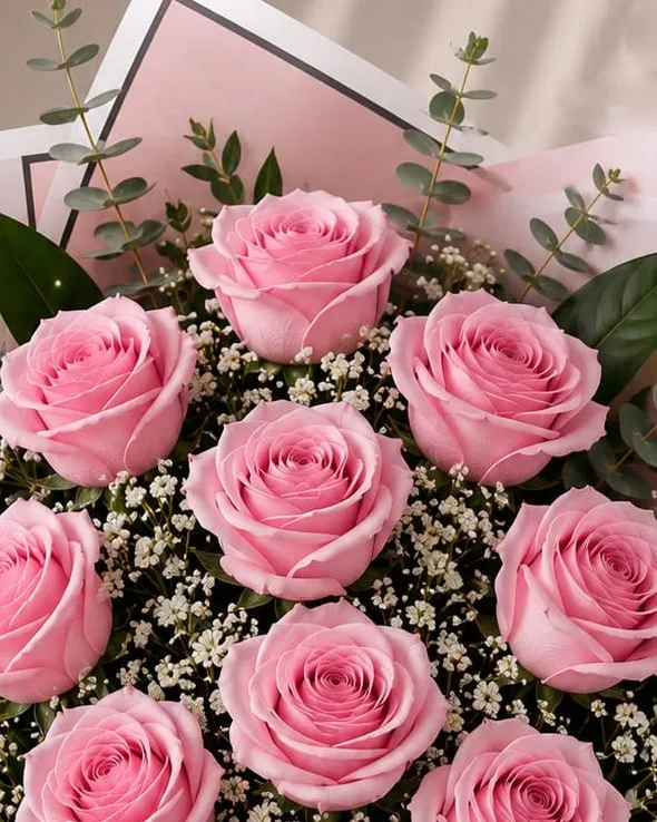 Detalle: ramo de nueve rosas rosadas con paniculata y eucalipto en papel rosado con cinta rosada