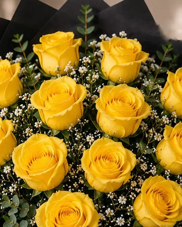 Detalle: ramo de doce rosas amarillas con paniculata y eucalipto en papel negro con cinta negra