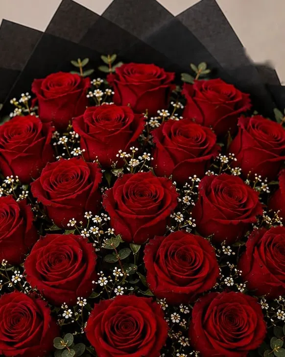 Detalle: ramo de veinticuatro rosas rojas con paniculata y eucalipto en papel negro con cinta negra