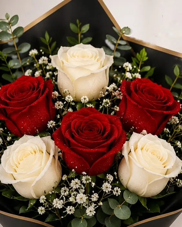 Detalle: ramo de rosas rojas y blancas con paniculata en papel negro con cinta roja