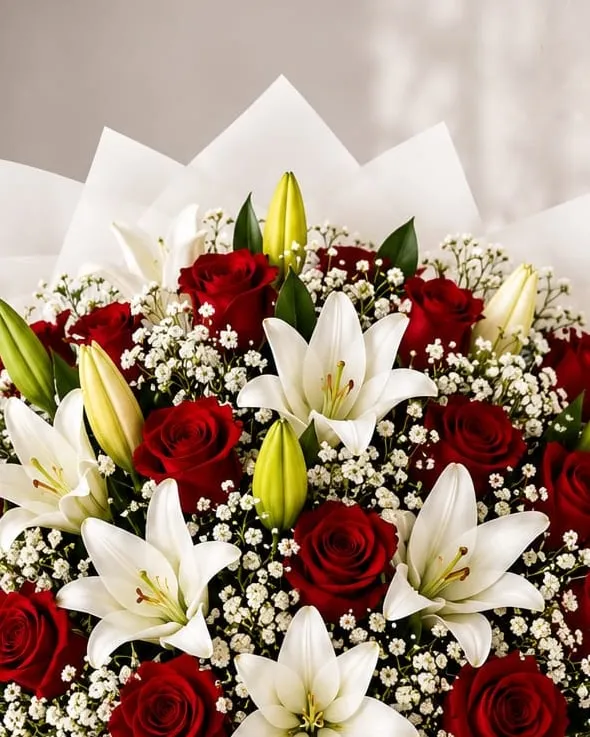 Detalle: ramo grande de rosas rojas y lilium blancos con paniculata en papel blanco con cinta roja