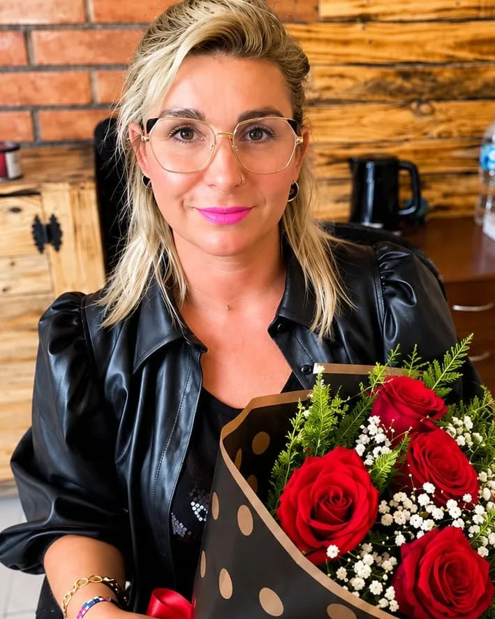 Mujer en una oficina con un ramo de rosas rojas en papel de lunares