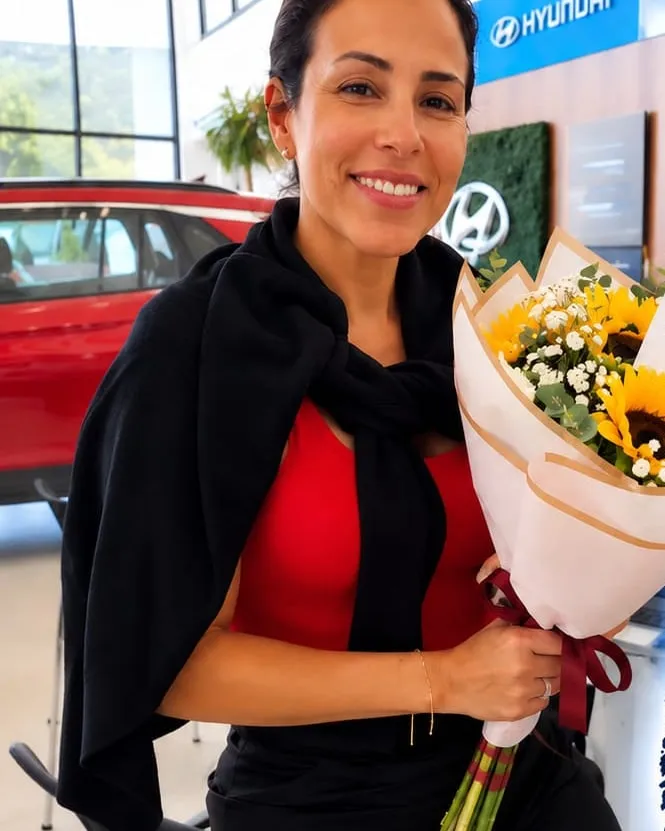 Mujer sonriendo con un ramo de girasoles en papel blanco