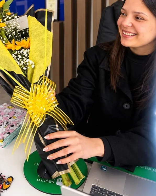 Mujer en su escritorio junto a un ramo de girasoles en papel negro y amarillo